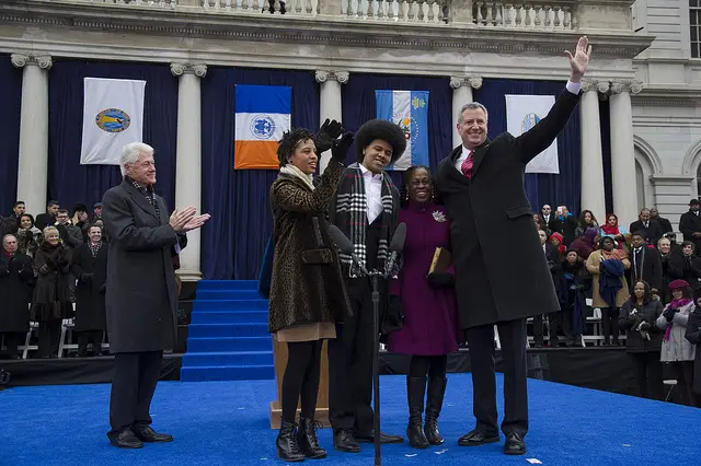 Bill Clinton claps for New York City Mayor Bill de Blasio and his wife Chirlane McCray and children Dante and Chiara as they wave to the crowd after taking the oath of office during his inauguration at City Hall in New York, January 1, 2014.